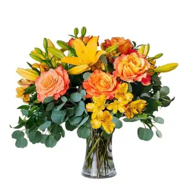 Bouquet of orange roses and yellow lilies in a glass vase