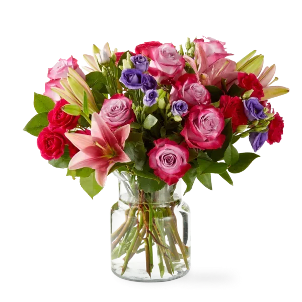 Mixed bouquet of pink and purple roses with lilies in a glass vase
