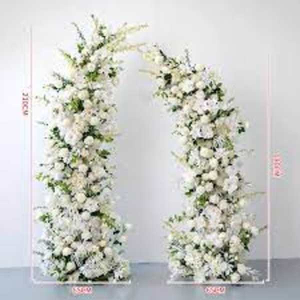 Tall asymmetrical white floral pillars forming an open wedding arch.