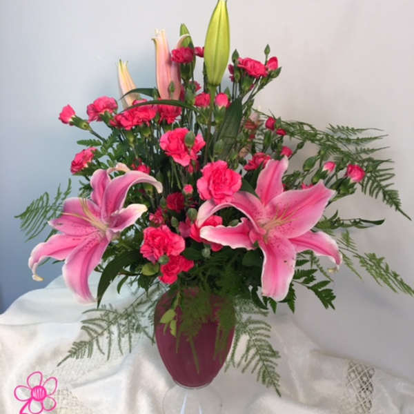 Pink lilies and carnations arranged in a vase