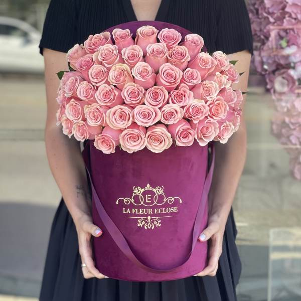 Large bouquet of pink roses in a magenta hatbox