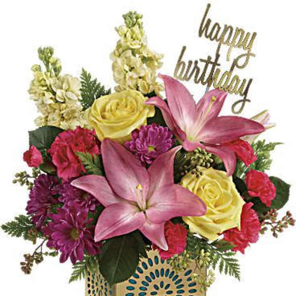 Birthday arrangement with pink lilies, yellow roses and mixed blooms in a gold cube container