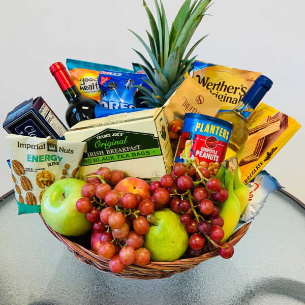 Gift basket with fruit, snacks, tea, and two bottles of wine