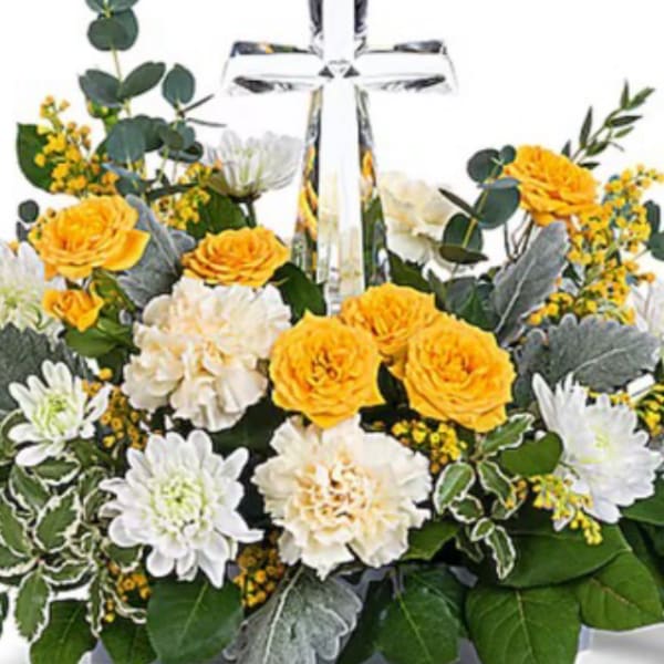 Yellow and white flower arrangement with a clear cross centerpiece