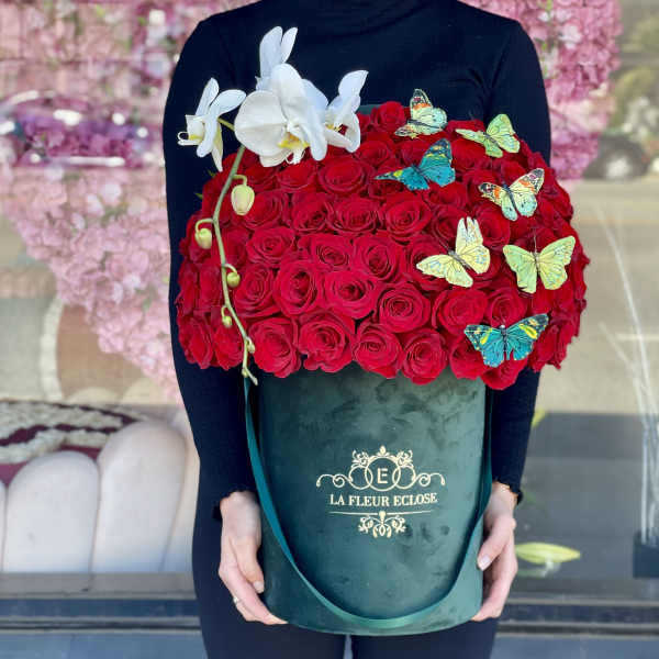 Large box of red roses with white orchids and butterfly decorations