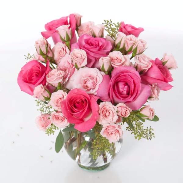 Pink and blush roses arranged in a clear glass vase