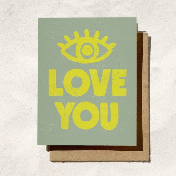 A greeting card with a yellow eye icon and the words LOVE YOU