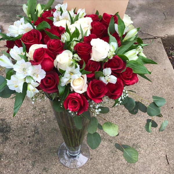 Bouquet of red and white roses in a clear glass vase