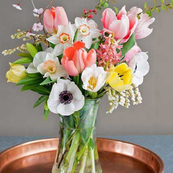 Mixed bouquet of tulips and daffodils in a glass vase