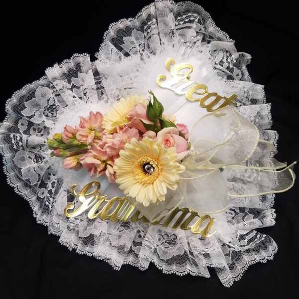 Lace-wrapped bouquet with pink and yellow flowers and gold script