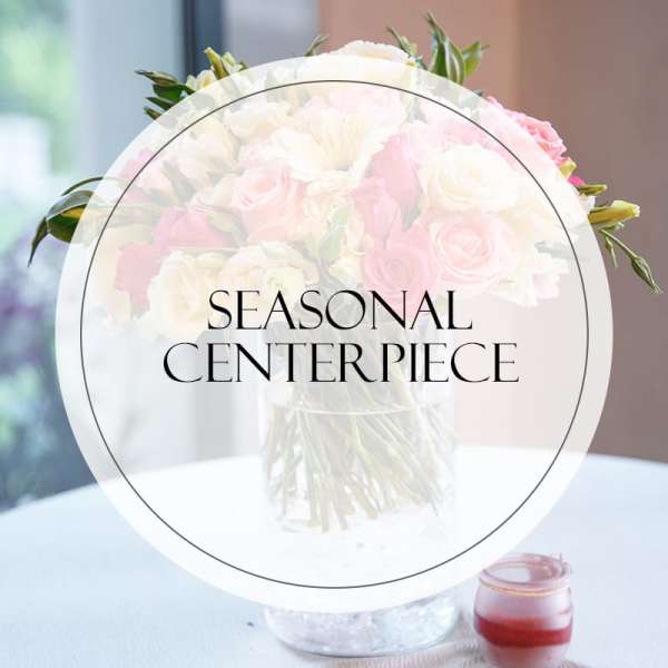 Pink and white flower centerpiece in a clear glass vase