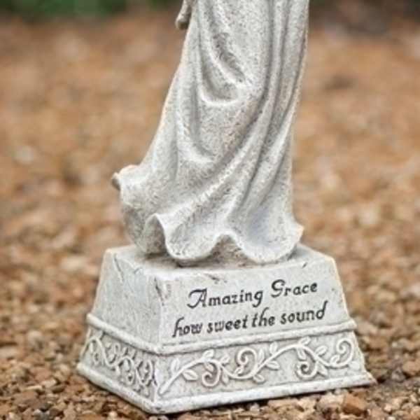 Angel statue holding pink roses with engraved text on the base