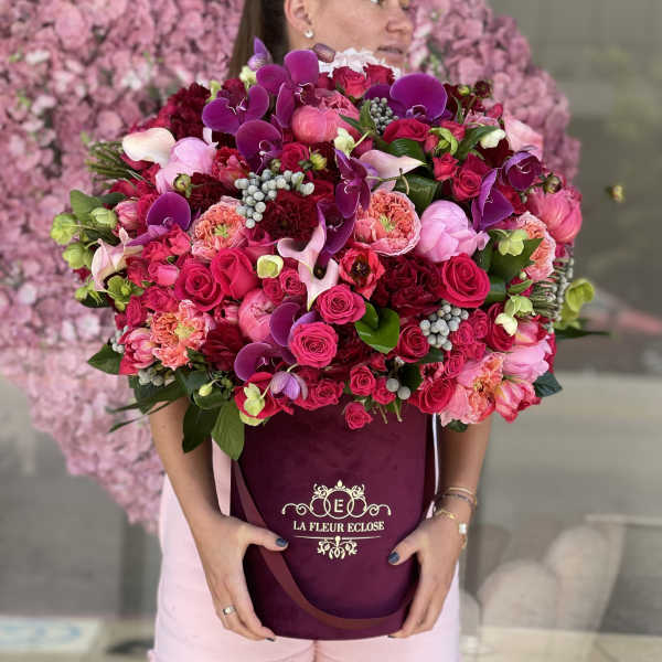 Large bouquet of pink and purple flowers in a burgundy box