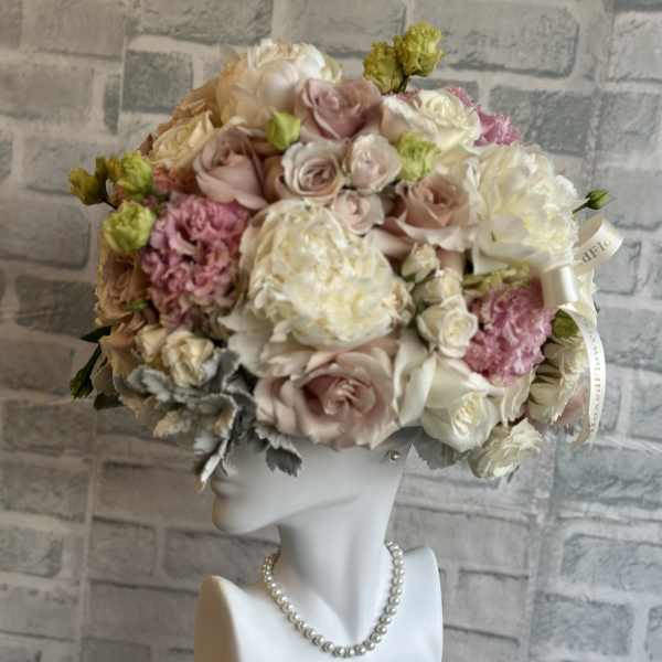 Pastel rose bouquet arranged on a white mannequin bust