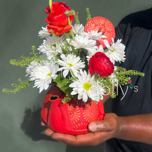 Red and white flower arrangement in a red patterned vase