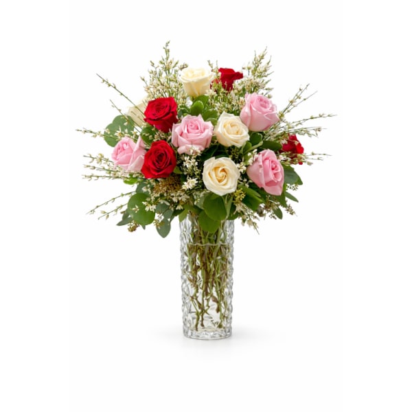 Tall glass vase of red, pink, and cream roses with small white filler flowers