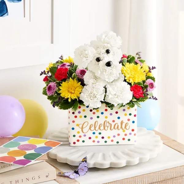 Colorful flower arrangement in a polka-dot box with a teddy bear centerpiece