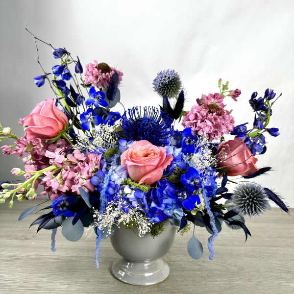 Blue and pink floral arrangement in a gray vase