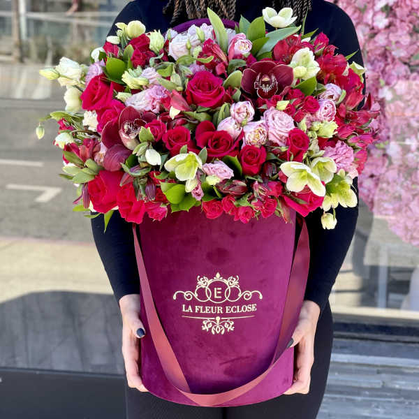 Large bouquet of pink and white flowers in a magenta hatbox