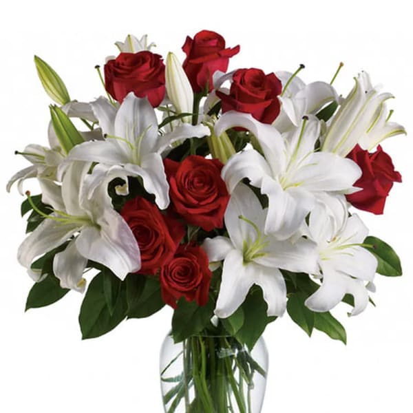 Red roses and white lilies in a clear glass vase
