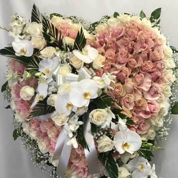 Heart-shaped bouquet of pink and white roses with orchids and ribbon