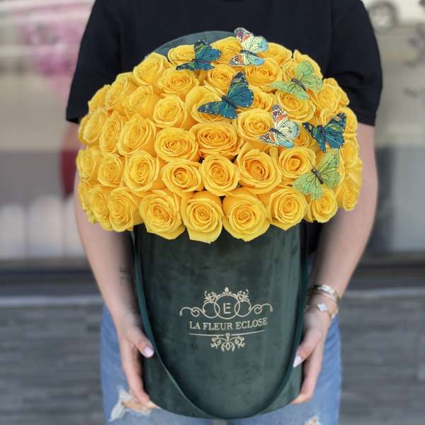 Large bouquet of yellow roses in a dark green box with butterfly decorations