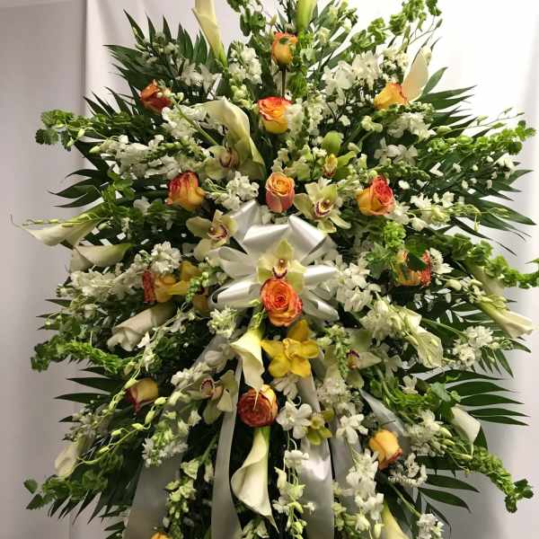 Large standing floral spray with white lilies, roses, and orchids