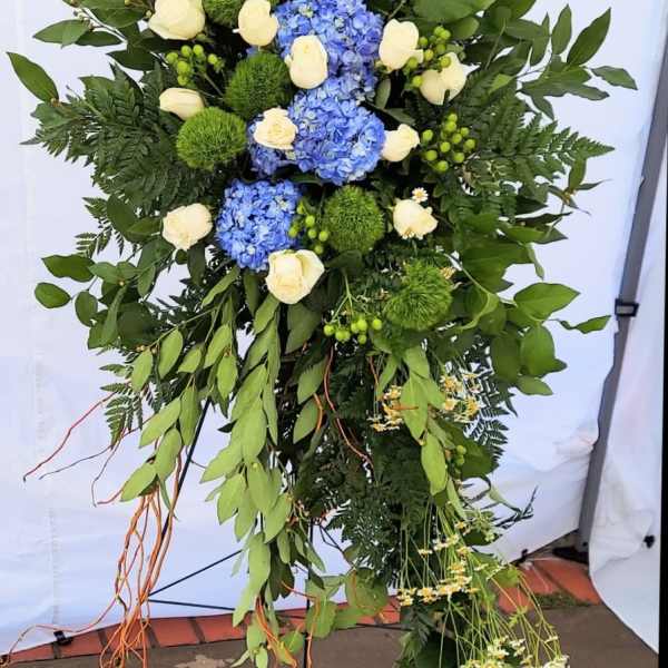 Tall floral standing spray with blue hydrangeas and white roses