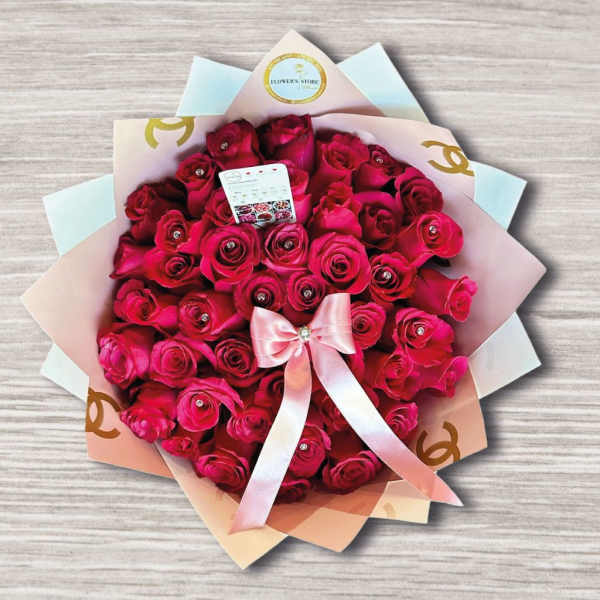 Bouquet of hot pink roses wrapped in pastel paper with a pink ribbon