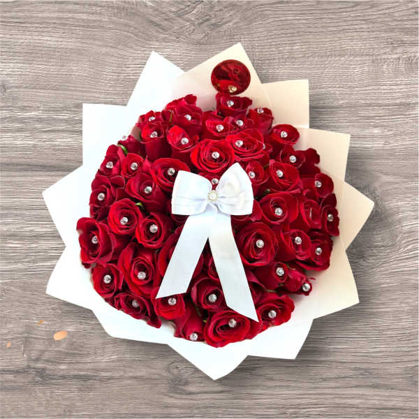 Bouquet of red roses with a white bow and paper wrap