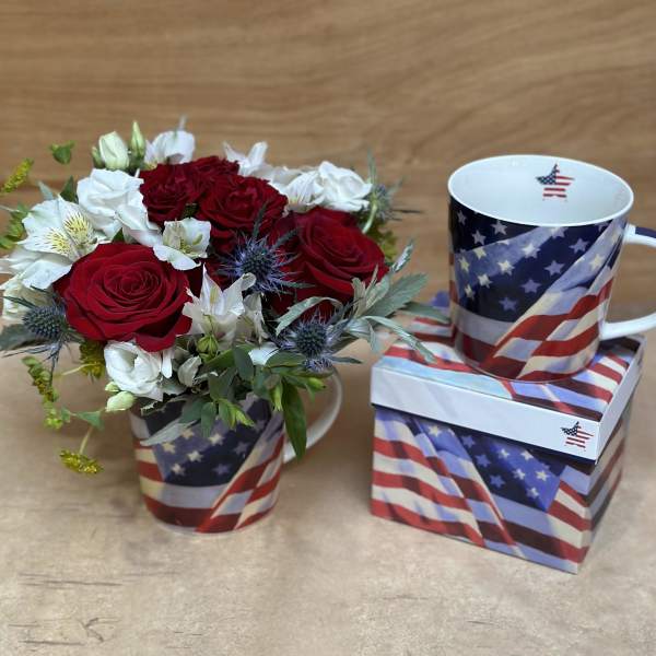 Red and white rose bouquet in a patriotic mug beside a matching mug and box