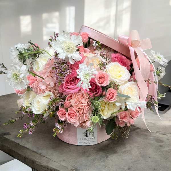 Pink and white rose bouquet in a round pink hat box with ribbon