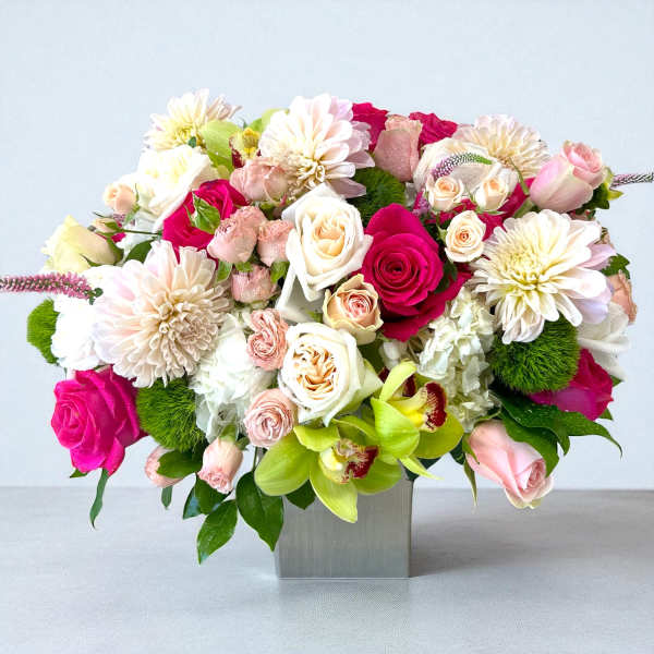 Mixed pink and white flower arrangement in a square vase