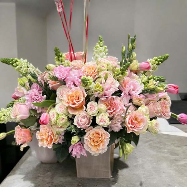 Large pastel flower arrangement in a square vase