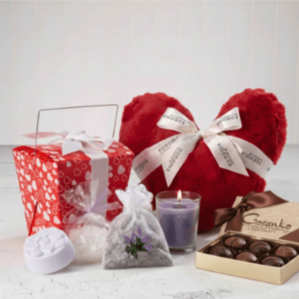 Romantic gift set with red heart pillow, candle, chocolates, and heart-print gift box