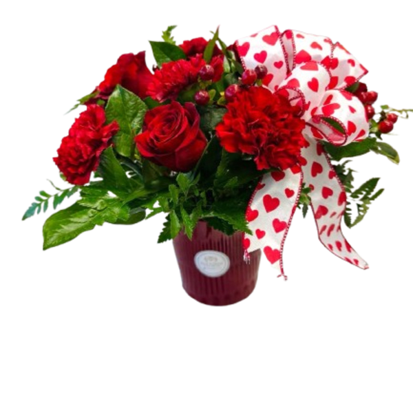 Red roses and carnations in a vase with a heart-patterned ribbon