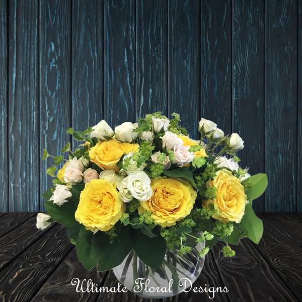 Yellow and white rose bouquet in a clear glass vase