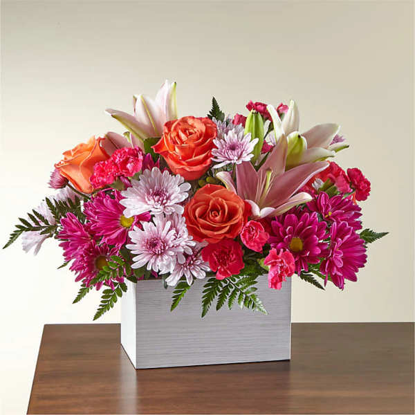 Mixed bouquet of roses, lilies, and daisies in a white box