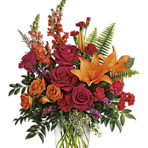 Mixed bouquet of roses and lilies in a clear glass vase