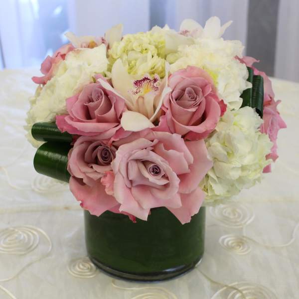 Pink roses and white flowers arranged in a green vase