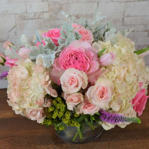 Pink and cream bouquet in a glass vase with hydrangeas and roses