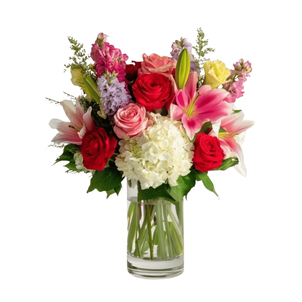 Mixed bouquet of roses, lilies, and hydrangea in a clear glass vase