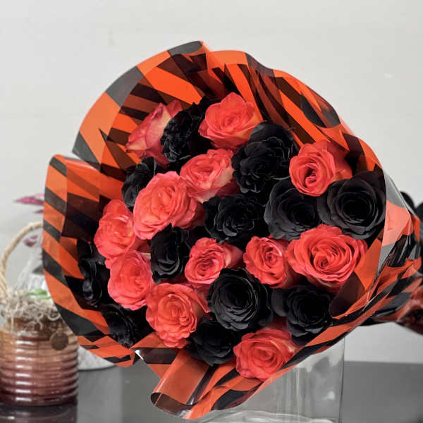 Bouquet of red and black roses wrapped in orange-and-black paper