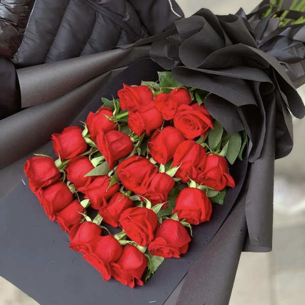 Bouquet of red roses wrapped in dramatic black paper