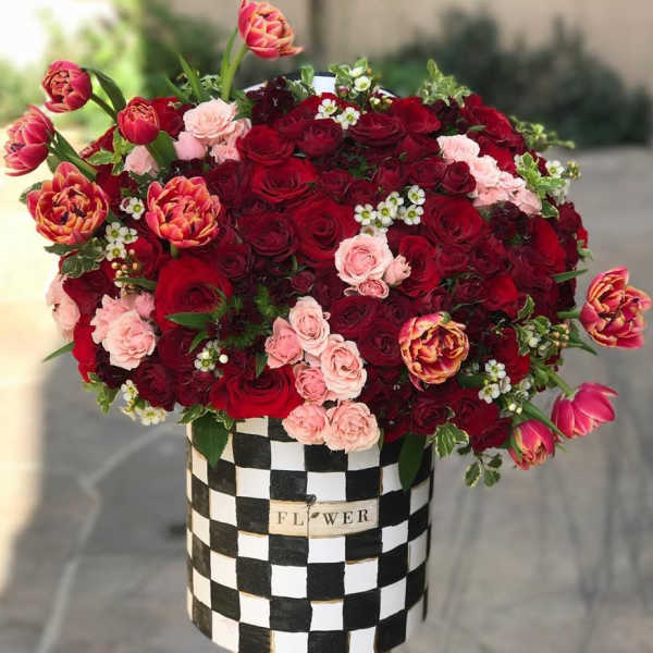 Bouquet of red and pink roses in a black-and-white checkered box