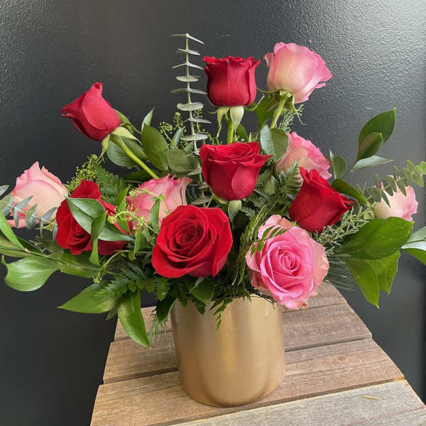 Bouquet of red and pink roses in a gold vase