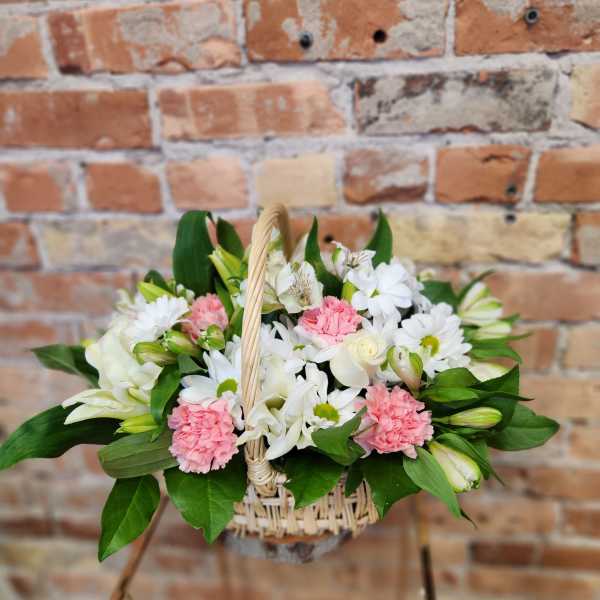 Basket arrangement of white and pink flowers with greenery