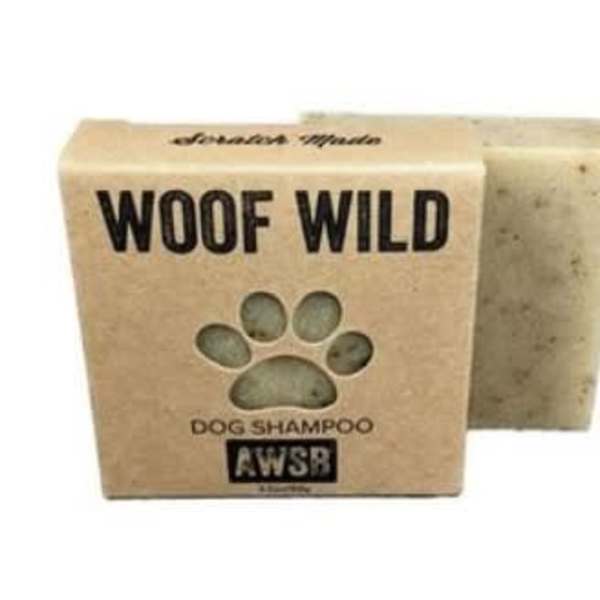 Bar of dog shampoo soap in a kraft box labeled Woof Wild with a paw-shaped cutout