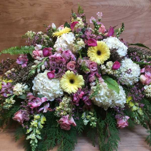 Large mixed floral arrangement with white hydrangeas, pink roses, and yellow gerbera daisies