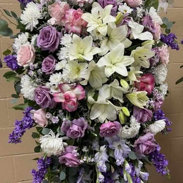 Large standing floral spray with pink, purple, and white blooms
